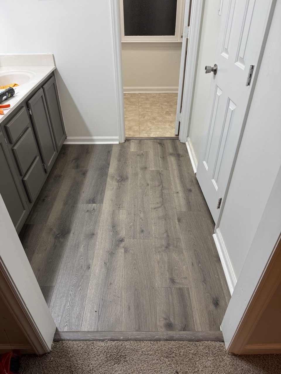Water-resistant LVP flooring installed in bathroom with gray vanity in Triangle NC home