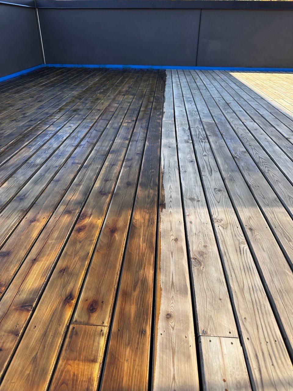 Deck boards being stained — half done showing the transformation in Triangle NC