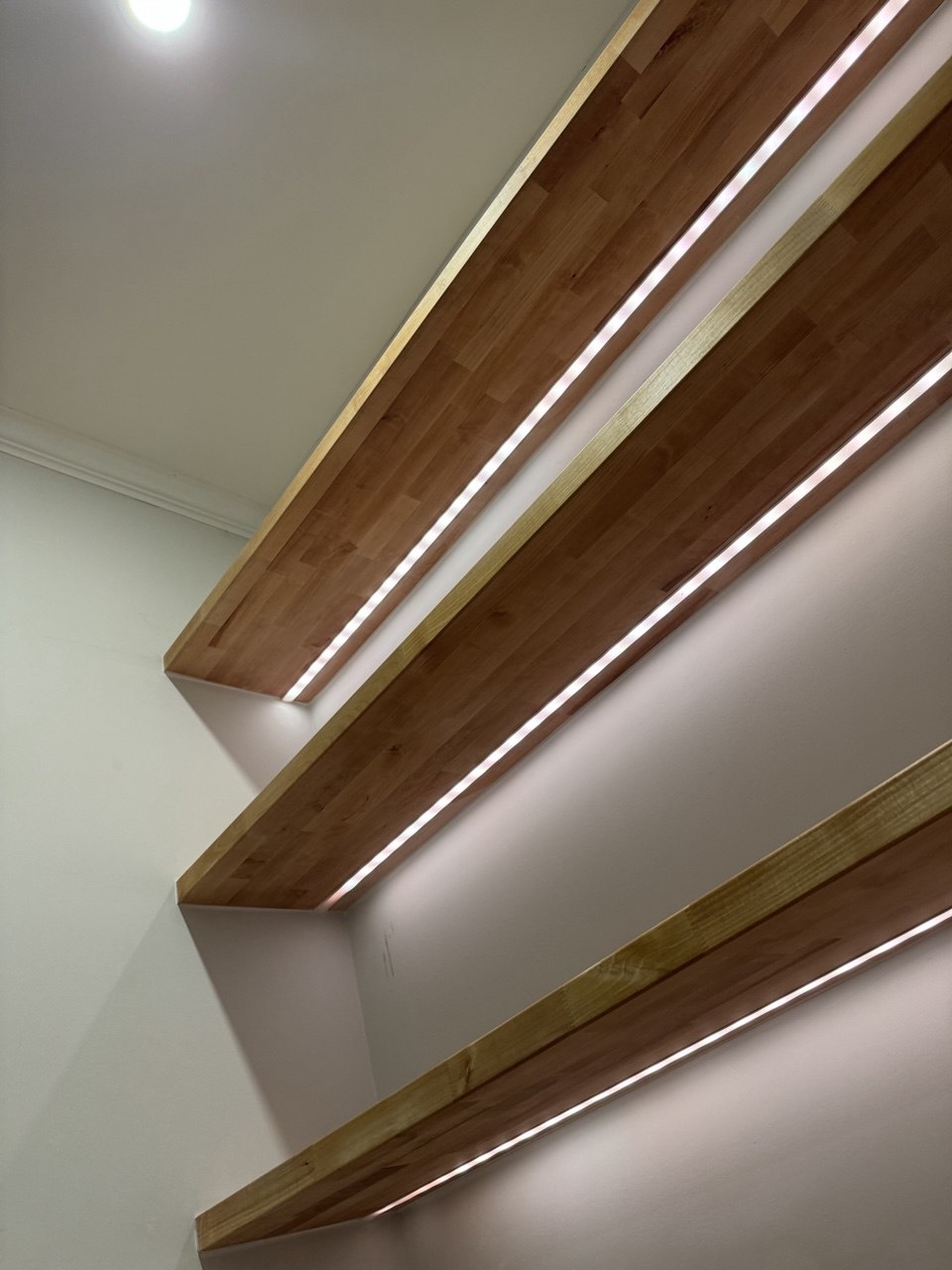 Custom butcher block floating shelves with hidden LED lighting installed in Triangle NC home