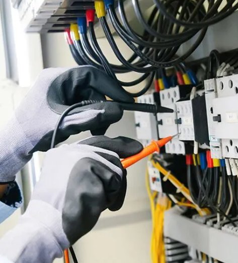 Electrician testing circuit breaker panel