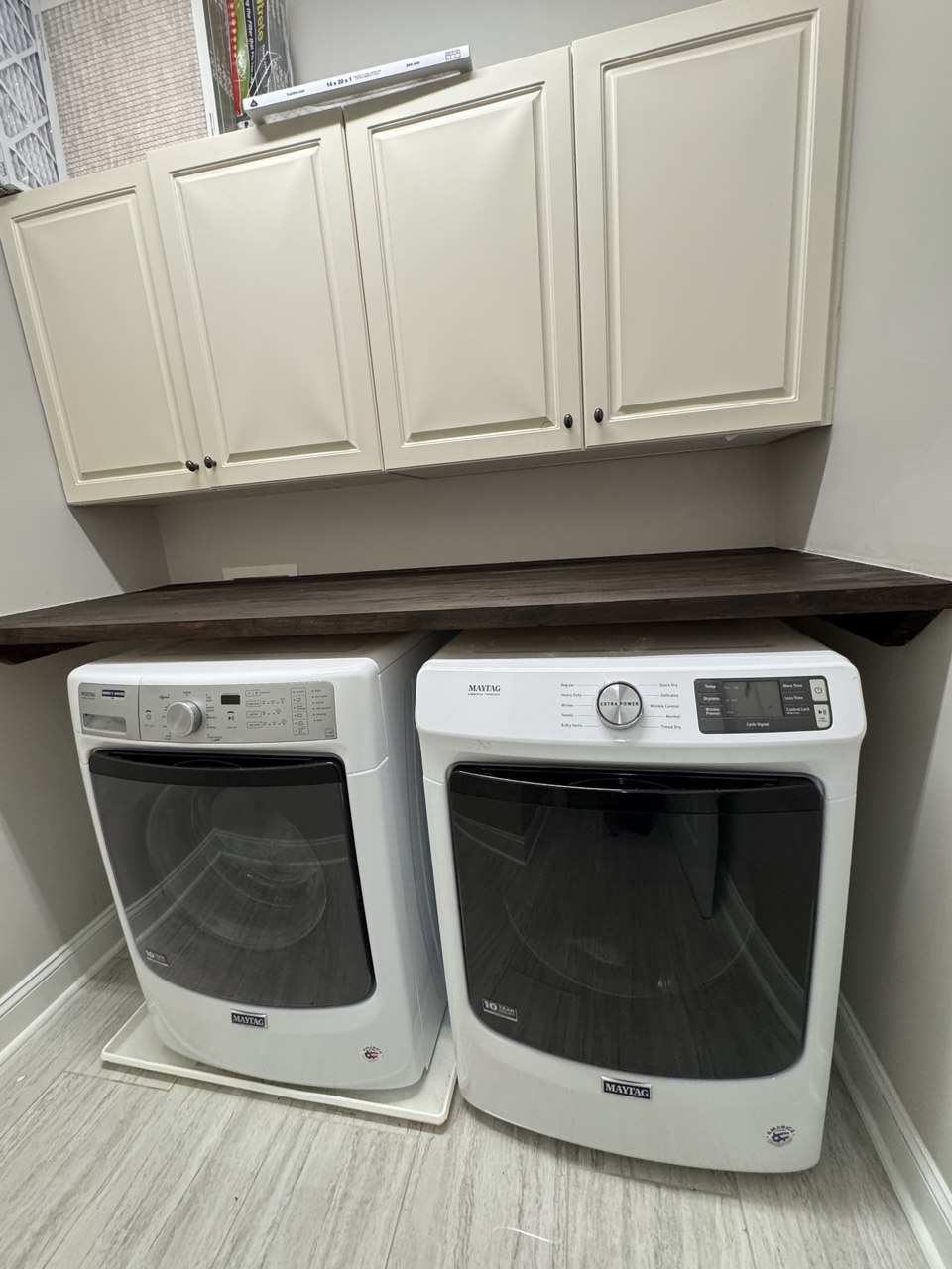 Custom countertop installed over washer and dryer with upper cabinets in Triangle NC laundry room