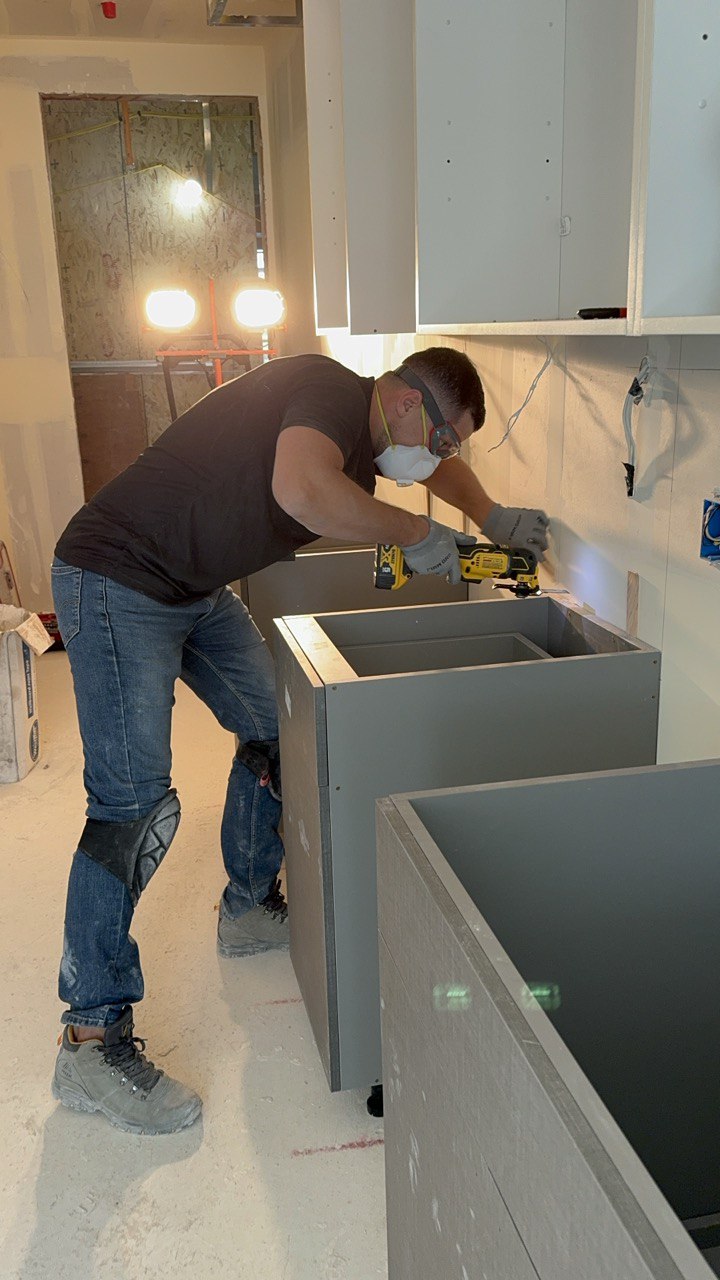 Mike from Holly Springs Handyman installing kitchen cabinets on a job site
